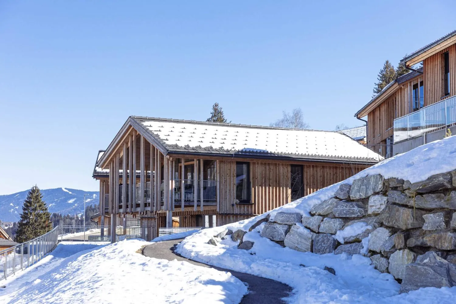 Outdoor-Pool mit Holzgebäude und Panoramablick auf Bergkette