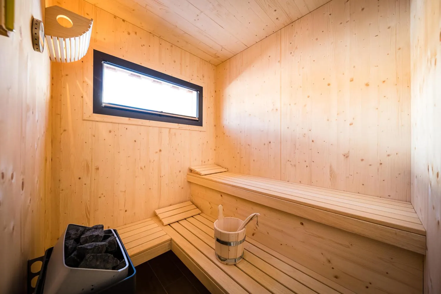 Moderne Holzsauna mit Fenster und Bergblick