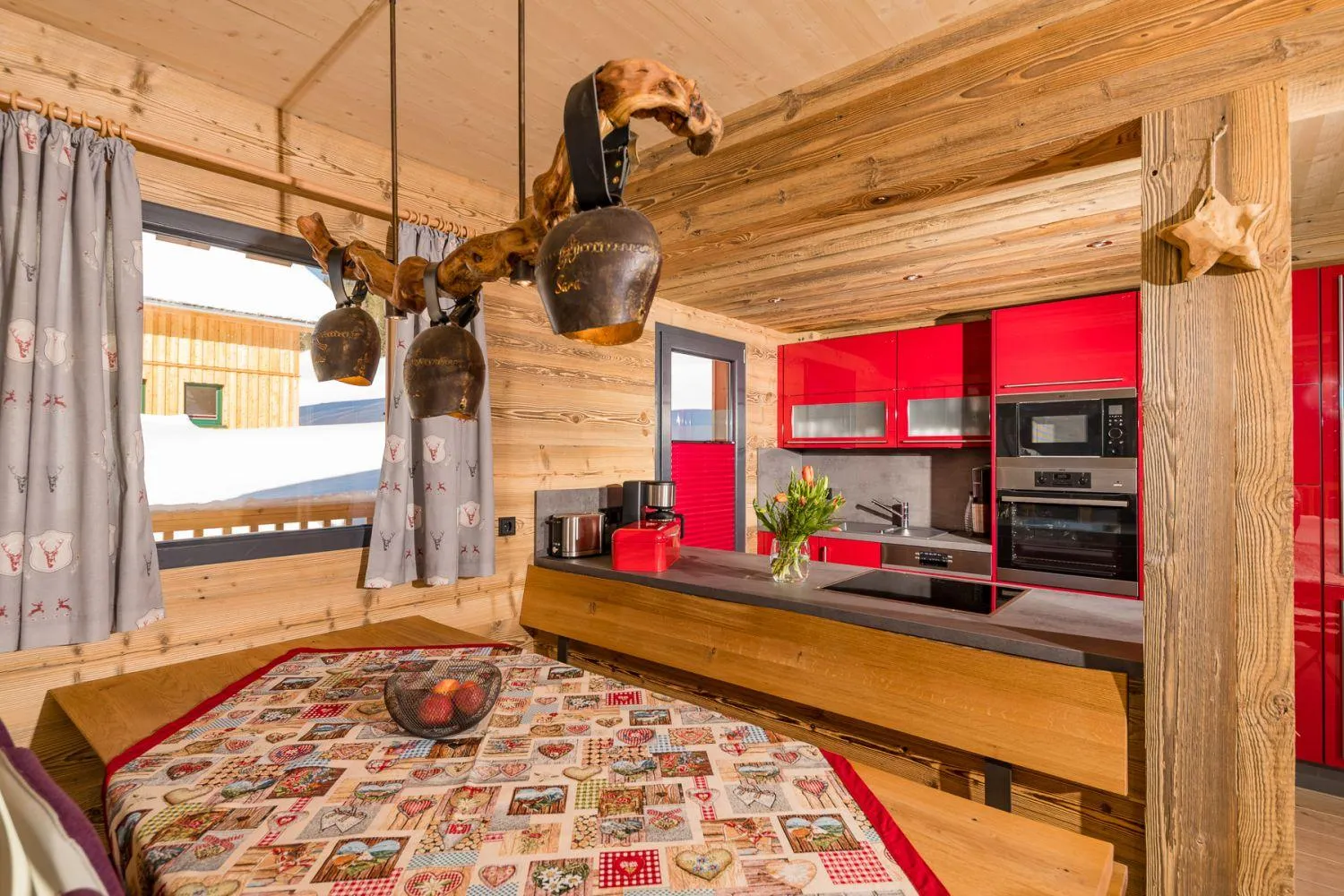 Schlafzimmer mit Holzvertäfelung, Hirsch-Hängeleuchten und Alpenblick