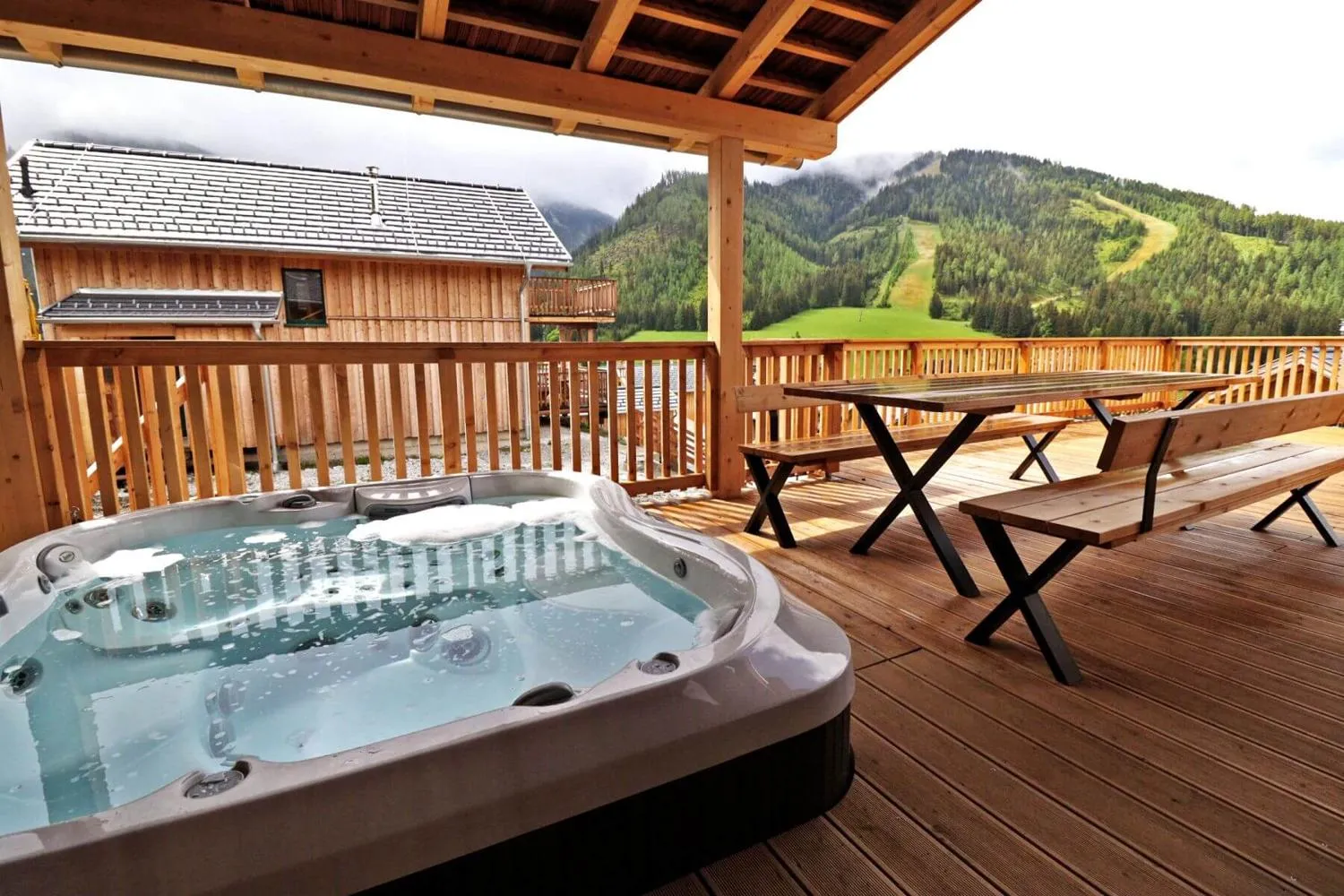 Whirlpool auf Holzterrasse mit Bergwald-Panorama