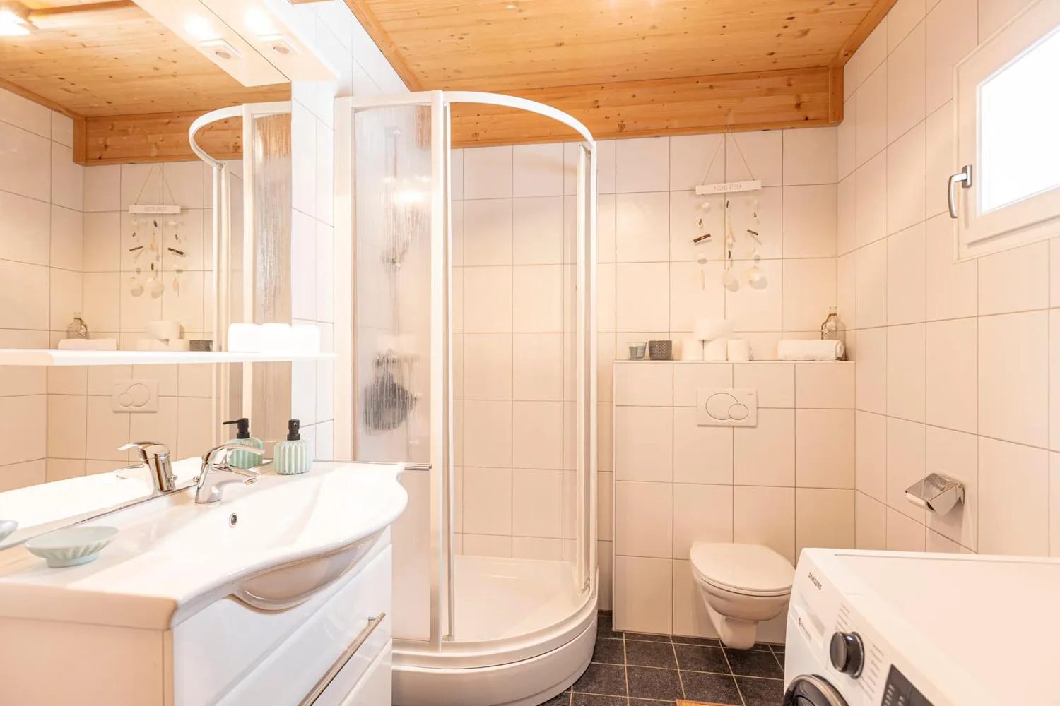 Badezimmer mit Duschkabine, Waschtisch und Holzdecke