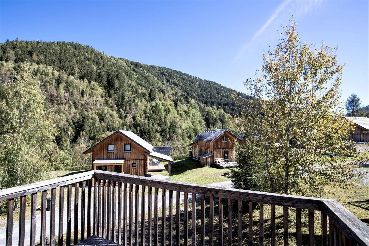 Veranda mit Aussicht auf Chalets und bewaldete Berglandschaft