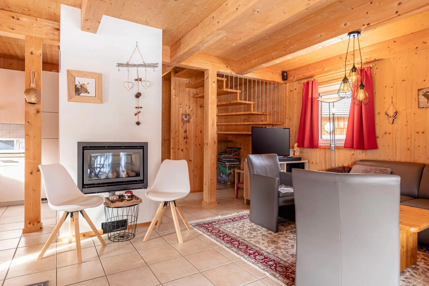 Holzverkleidetes Wohnzimmer mit Kamin, Sofa und rotem Akzent