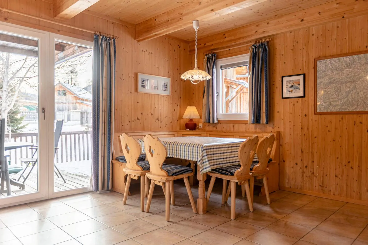 Esszimmer mit Holztisch, Holzstühlen und Bergblick durch Fenster