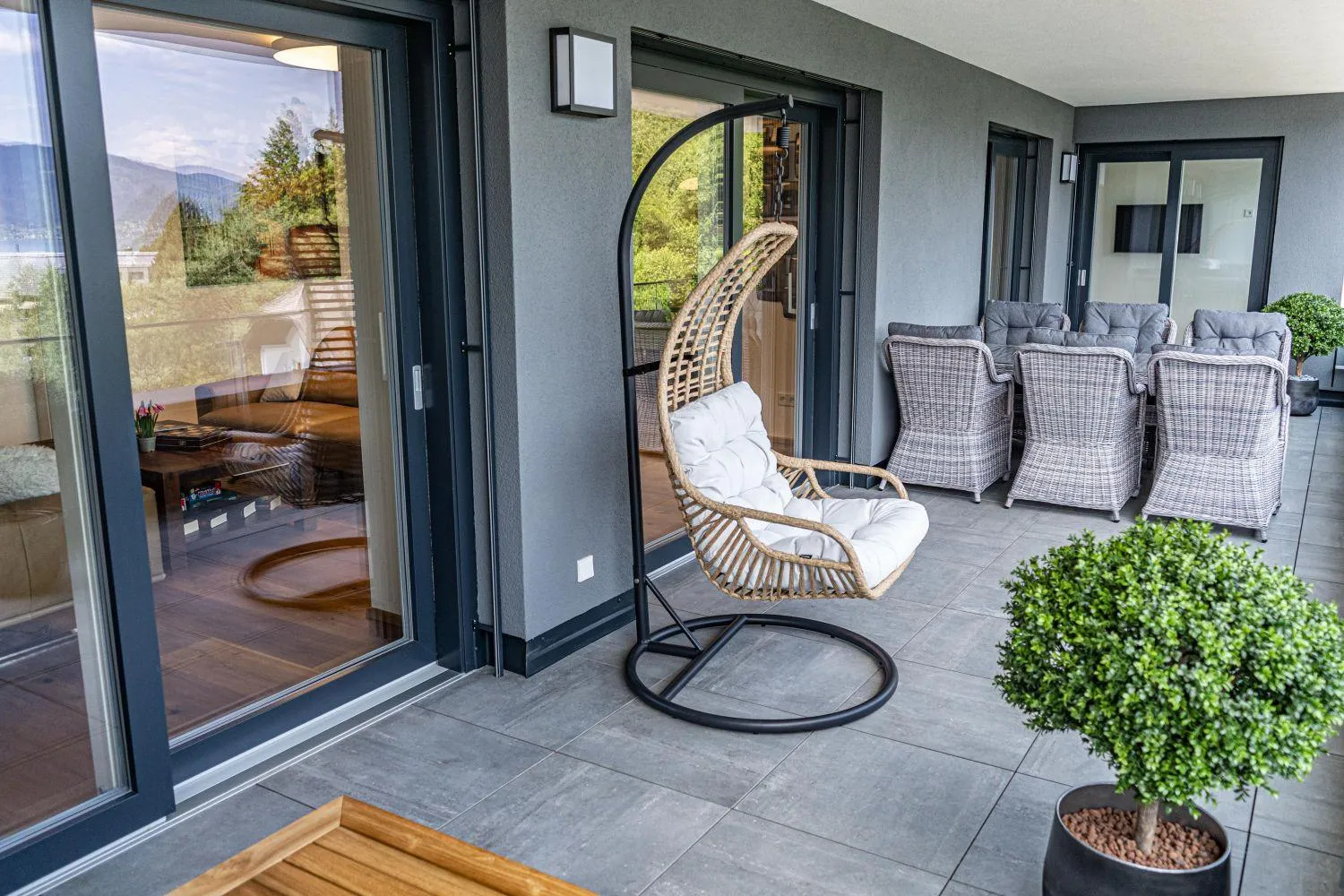 Moderne Terrasse mit Korbsessel, Loungebereich und Bergblick