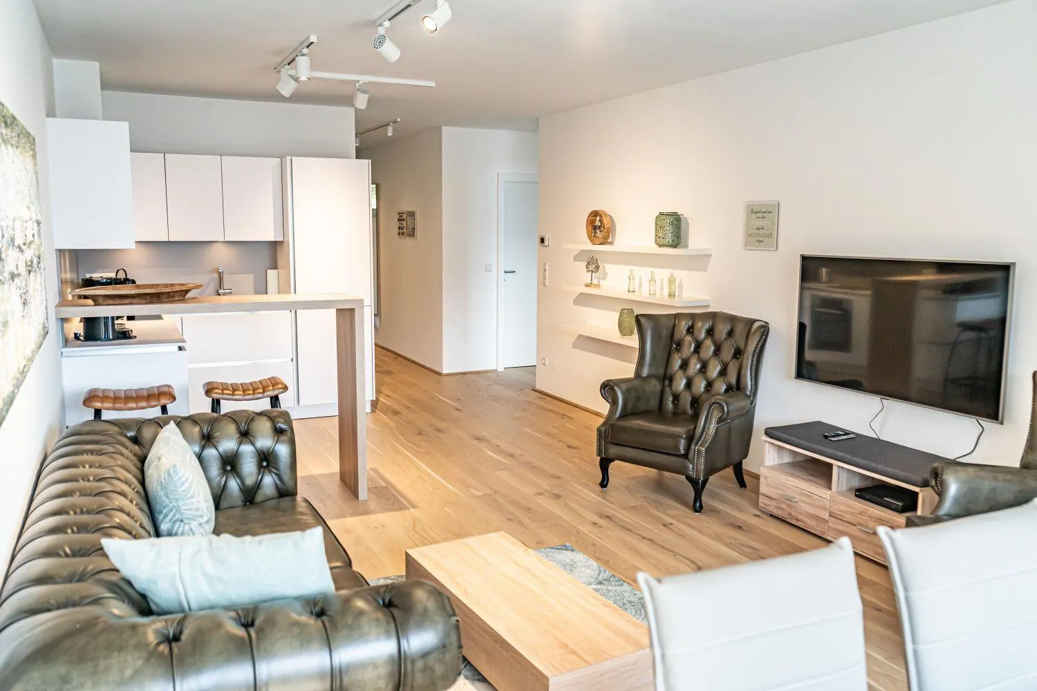 Modernes Wohnzimmer mit grünem Sessel und Designermöbeln