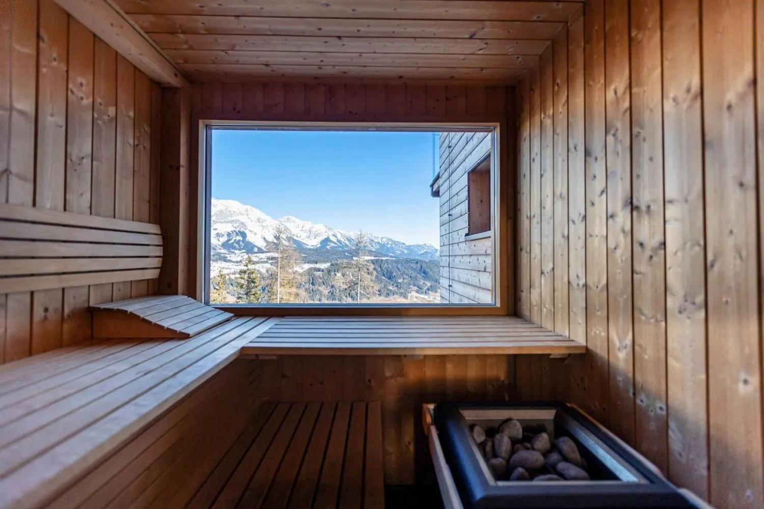 Whirlpool auf Holzterrasse mit Panoramablick auf Skigebiet