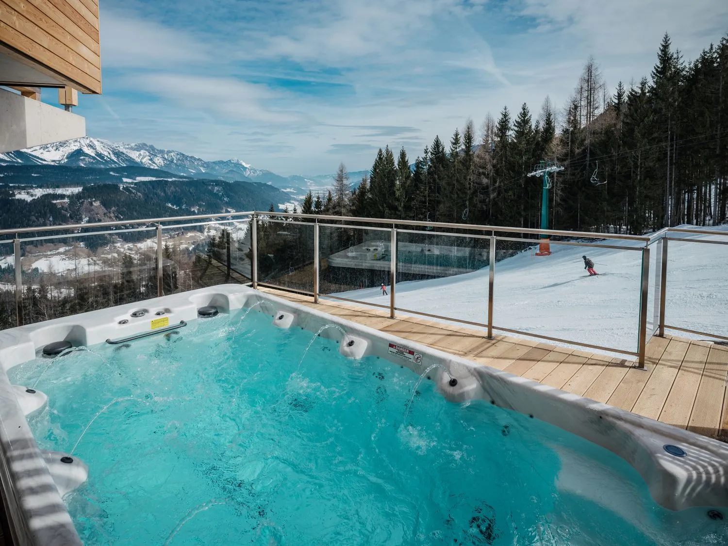Whirlpool auf Terrasse mit Blick auf schneebedeckte Berglandschaft