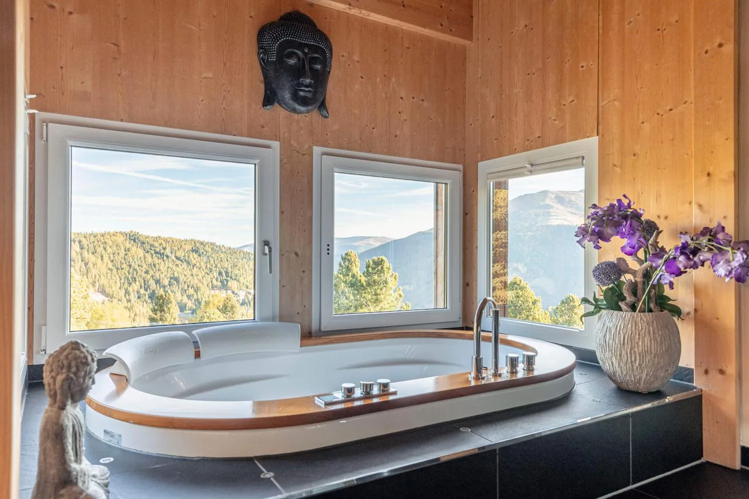Luxus-Badezimmer mit großer Wanne und Panoramablick auf Berglandschaft