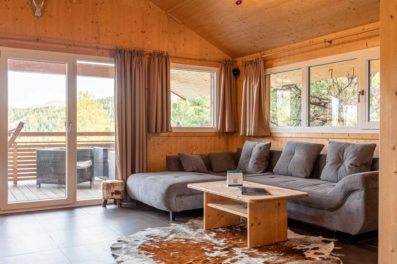 Schlafbereich mit großem Schlafsofa, Bergblick durch moderne Fenster