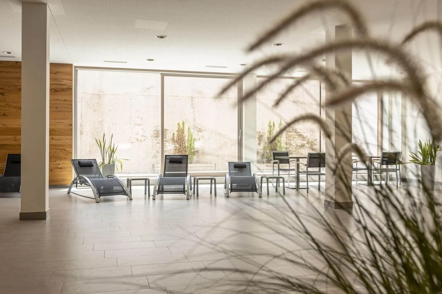 Moderner Wellnessbereich mit Relaxliegen und Panoramafenster