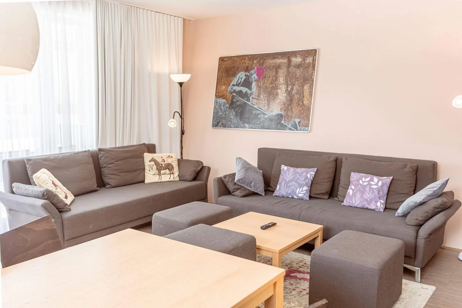 Wohnzimmer mit grauem Sofa, Beistelltisch und Hirschkopf an der Wand