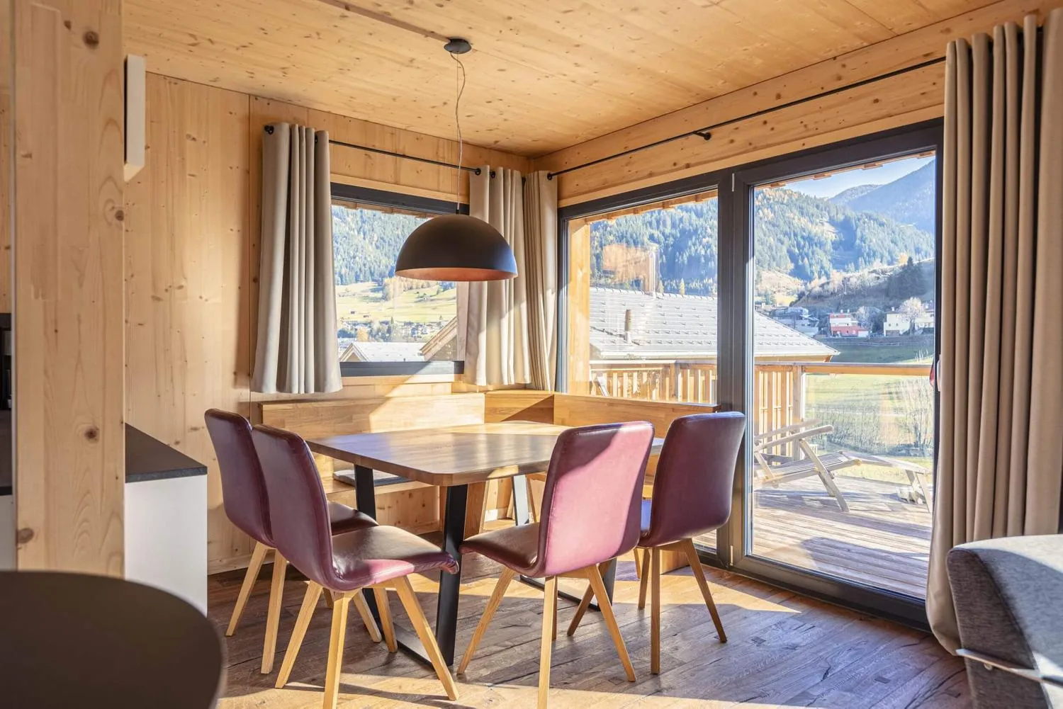 Esszimmer mit Bergblick, Holzrundtisch und modernem Interieur