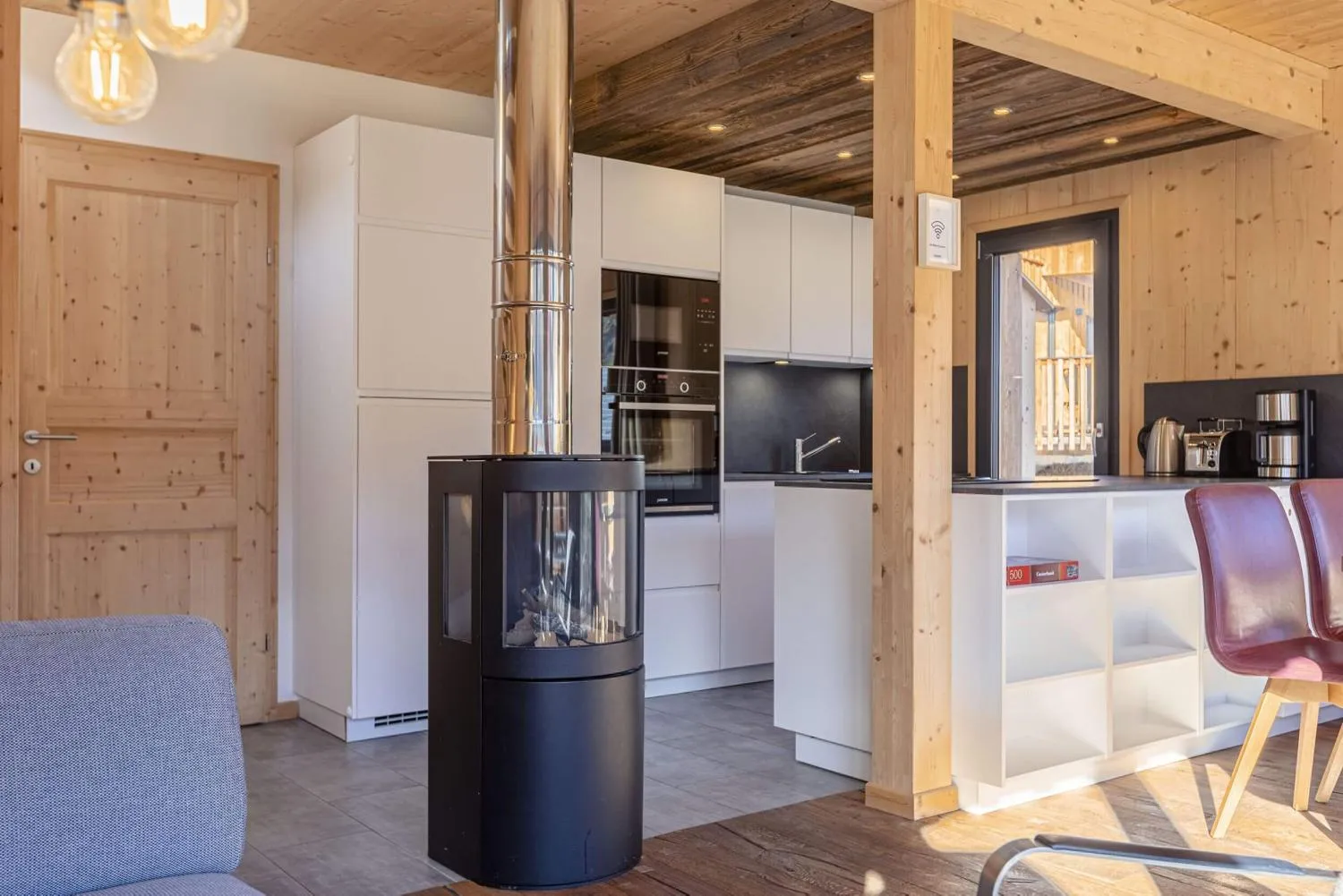 Moderne Küche mit Kochinsel und schwarzem Stahlabzug in Holzambiente