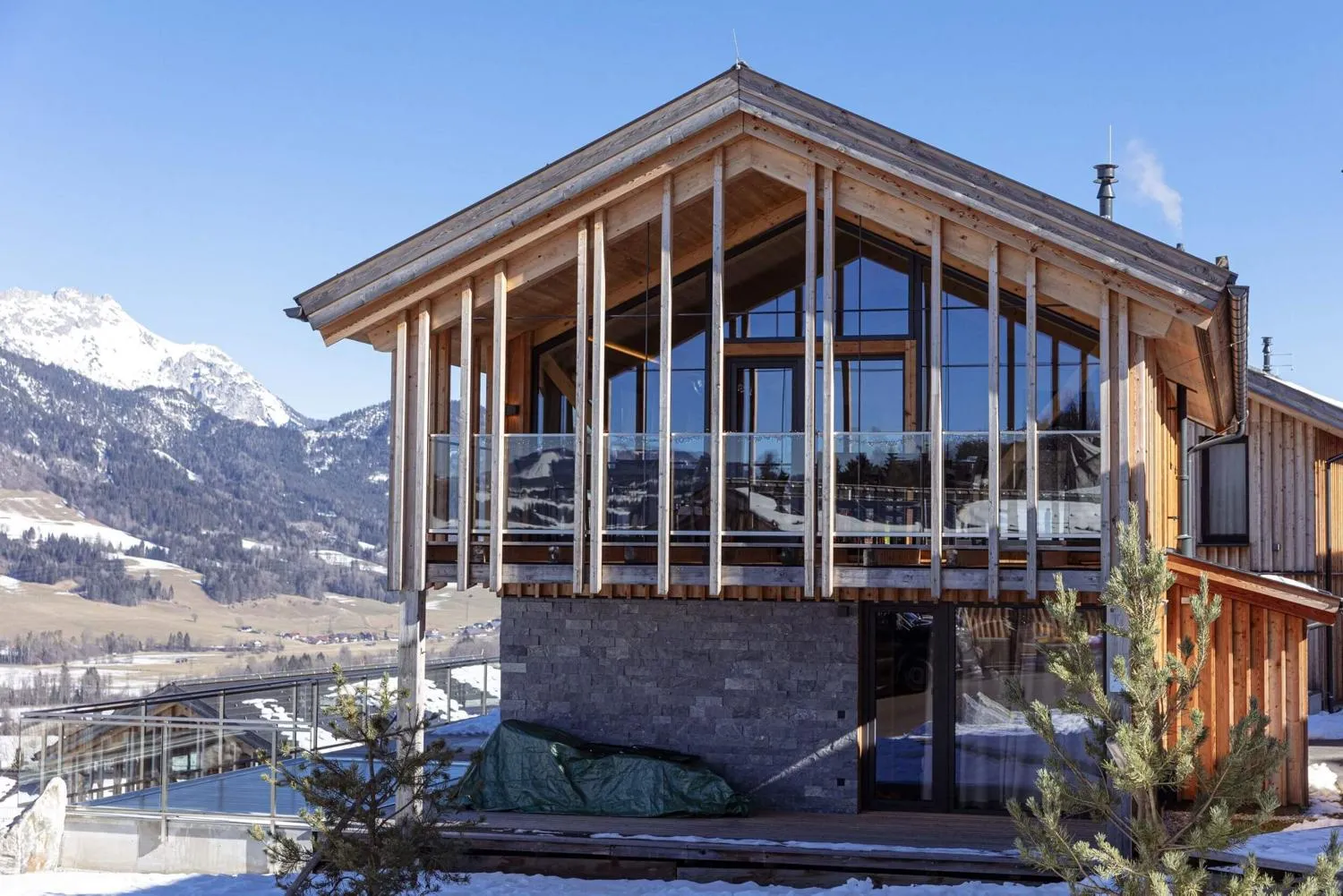 Modernes Holzhaus mit Glasveranda und Lounge-Bereich mit Bergblick