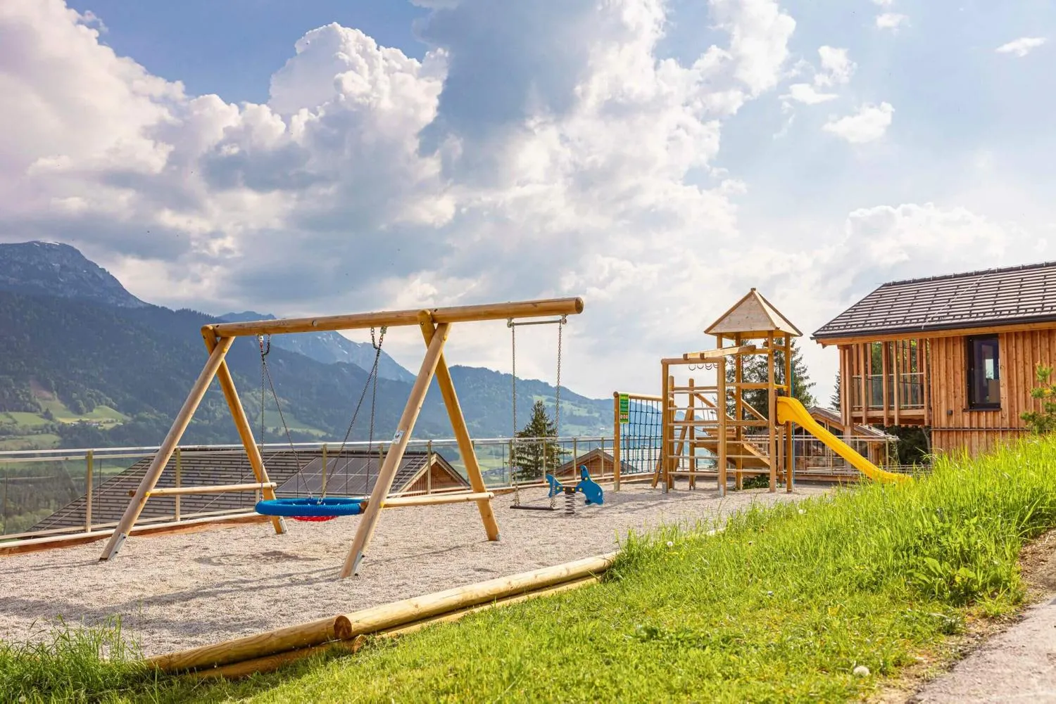 Modernes Holzhaus mit großer Glasfassade und schneebedeckten Bergen