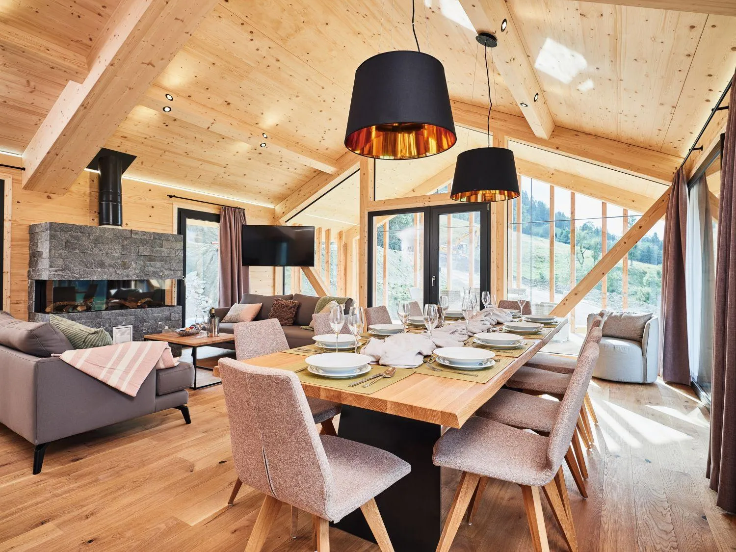 Wohnzimmer und Essbereich mit Holzdecke und modernem Kamin