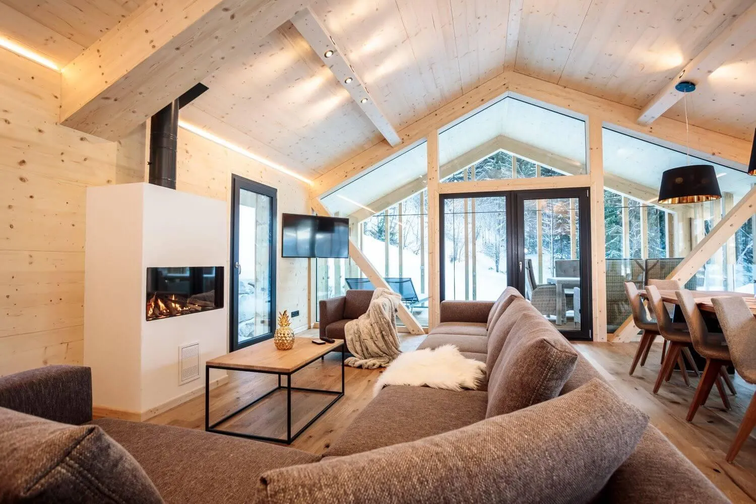 Offenes Wohnzimmer mit Wendeltreppe, Kamin und Bergblick