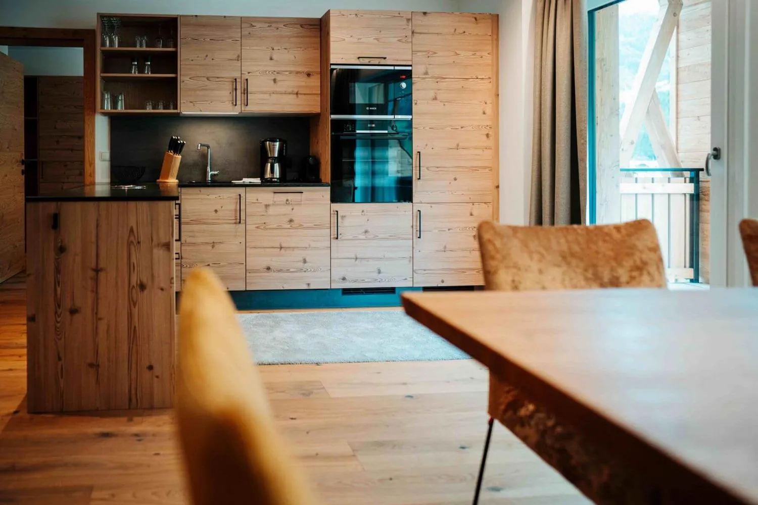 Speisezimmer mit Holztisch, Stühlen und Panoramablick auf Tal