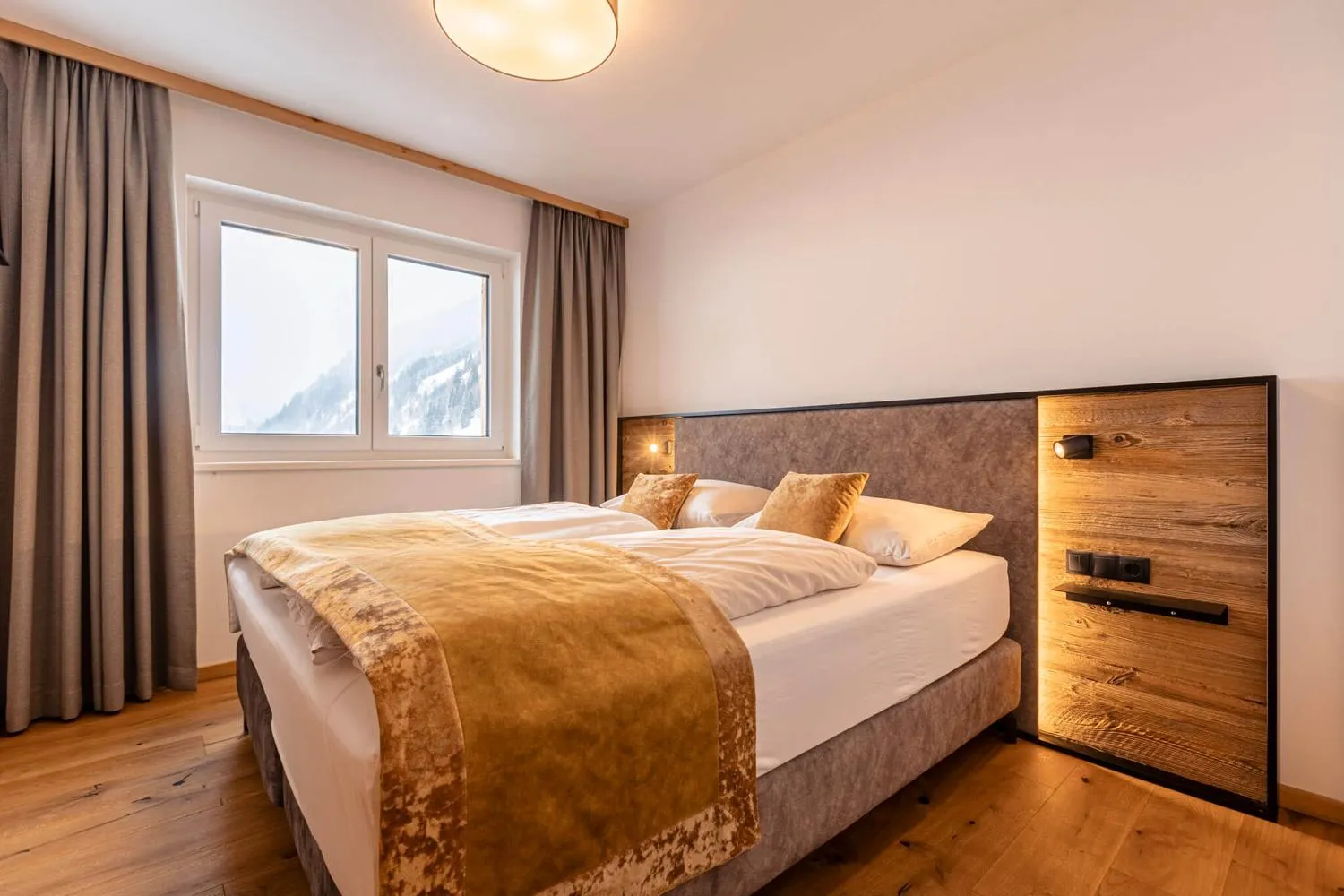 Helles Dachzimmer mit breitem Fenster auf Berglandschaft