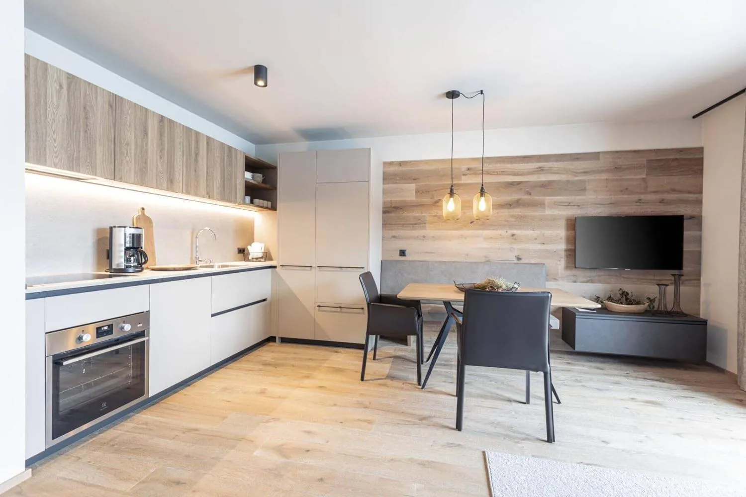 Moderne Küche mit Holzfronten, weißen Schränken und Essbereich