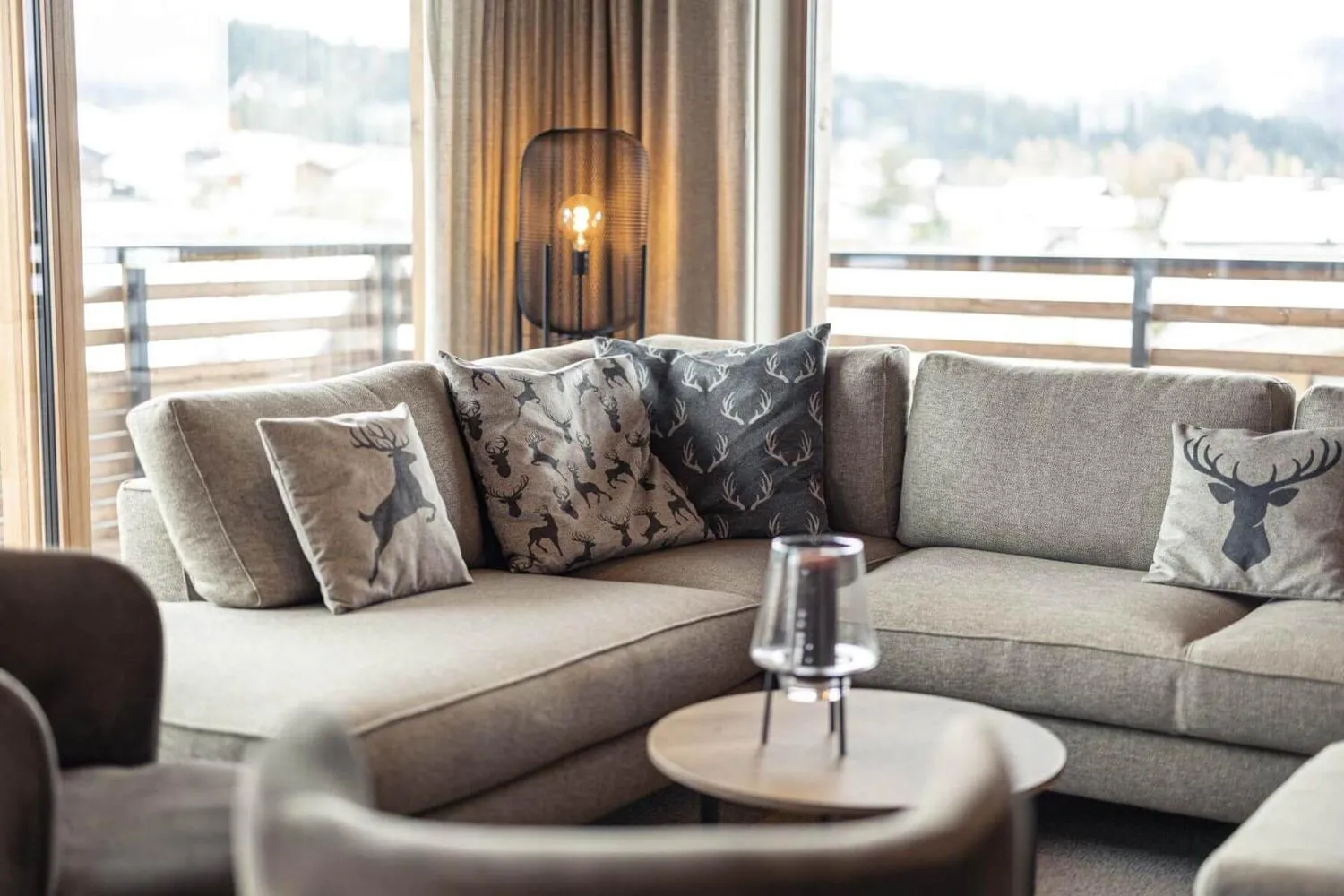 Schlafzimmer mit Holzakzentwand, breitem Bett und Bergfenster
