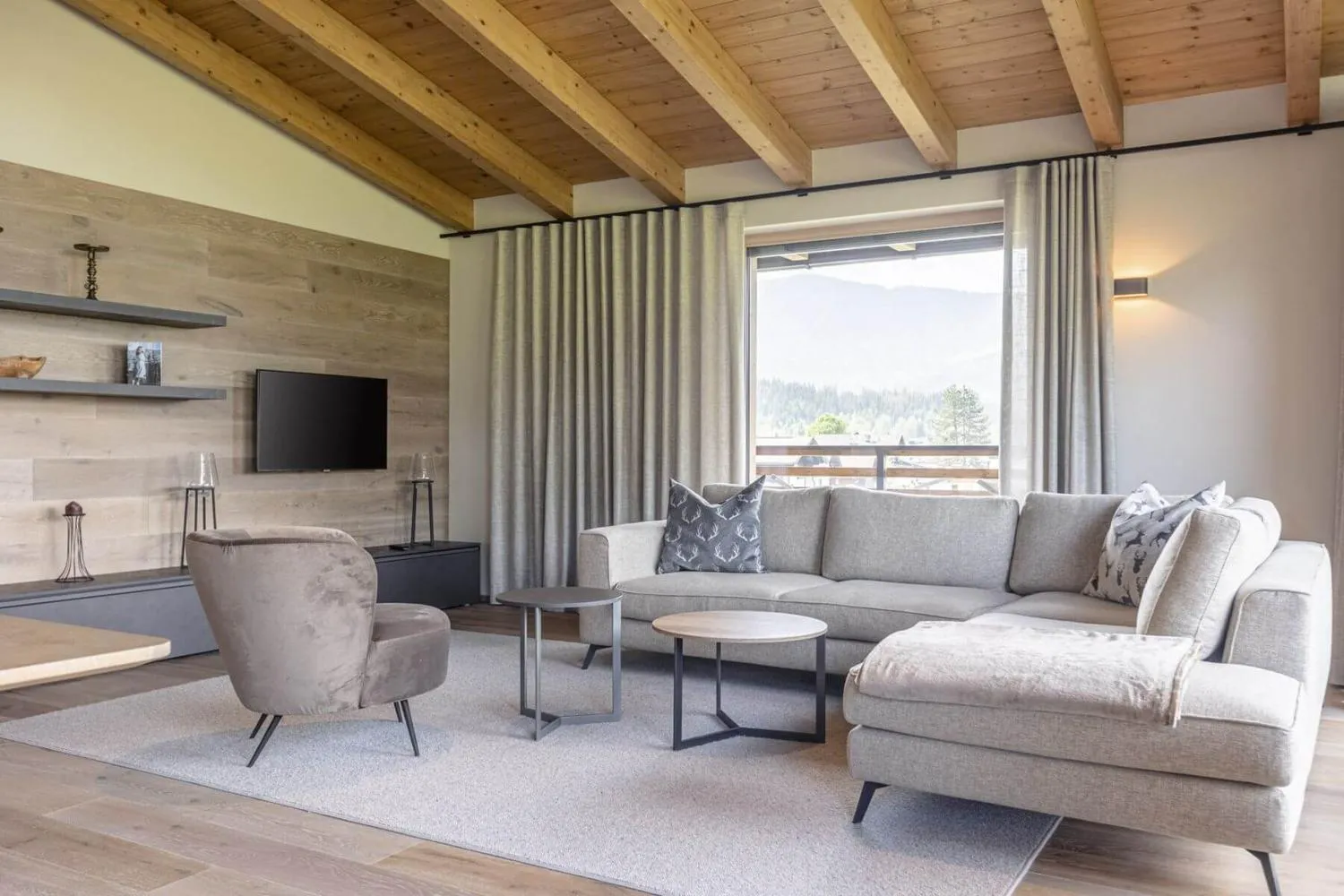 Großes Wohnzimmer mit Holzdecke, Loungebereich und Kaminofen