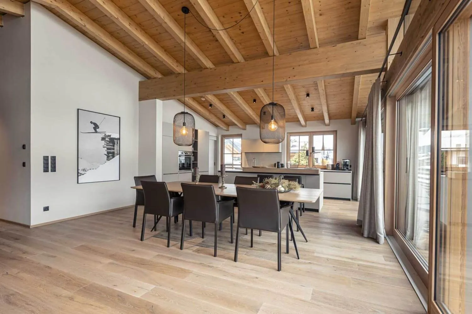 Esszimmer mit Holztisch, modernen Hängeleuchten und Bergpanorama