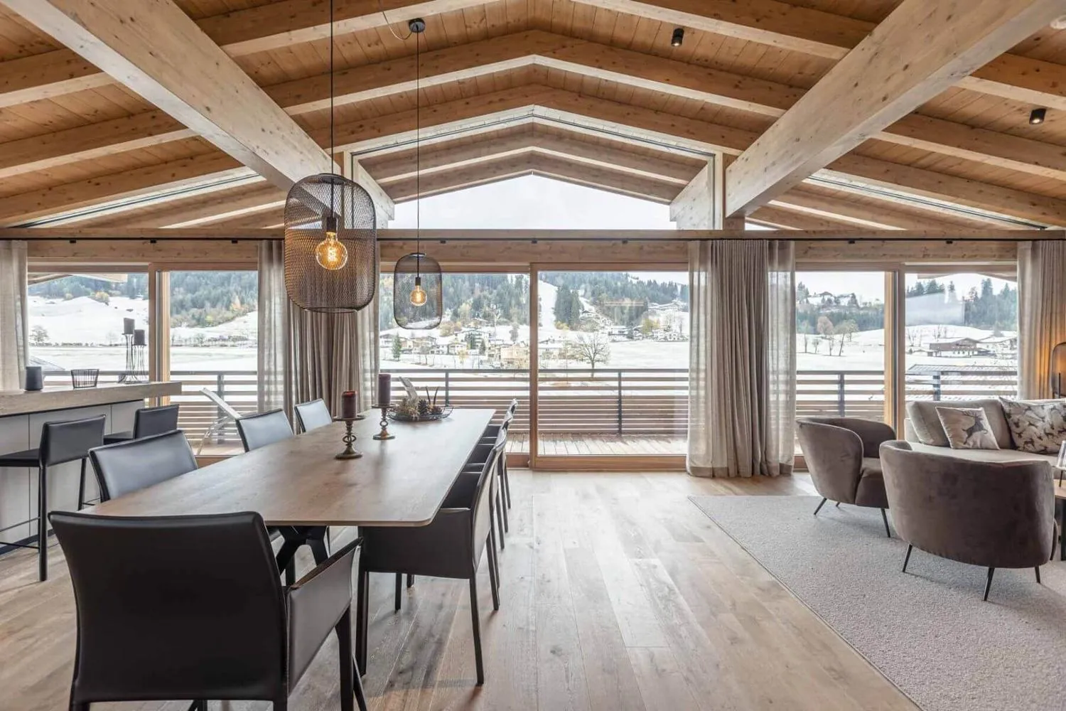 Wohnzimmer mit beigem Sofa, Kissen mit Hirschmotiven und Balkon