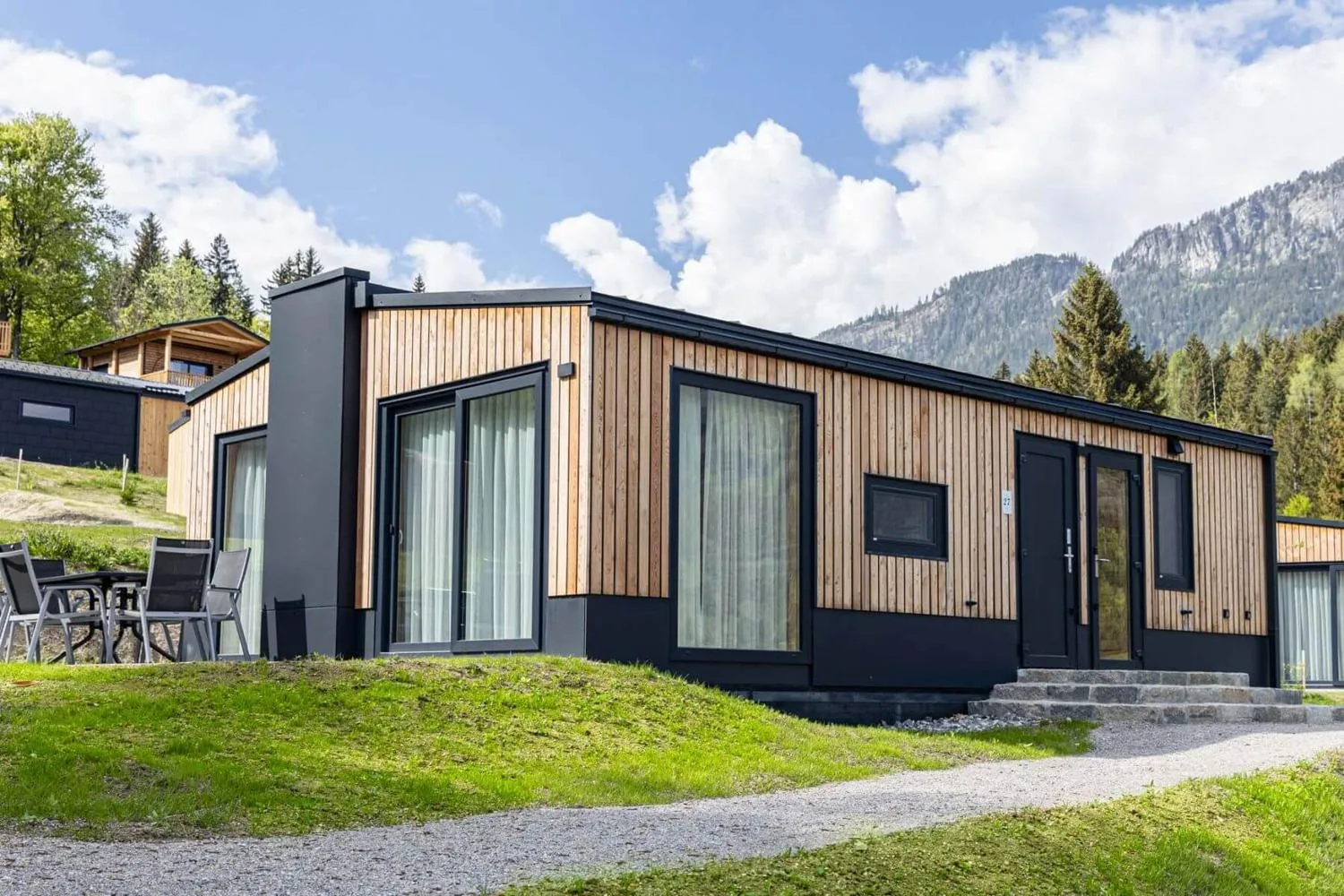 Schwarzes modernes Chalet mit Holz-Metallverkleidung und Terrasse