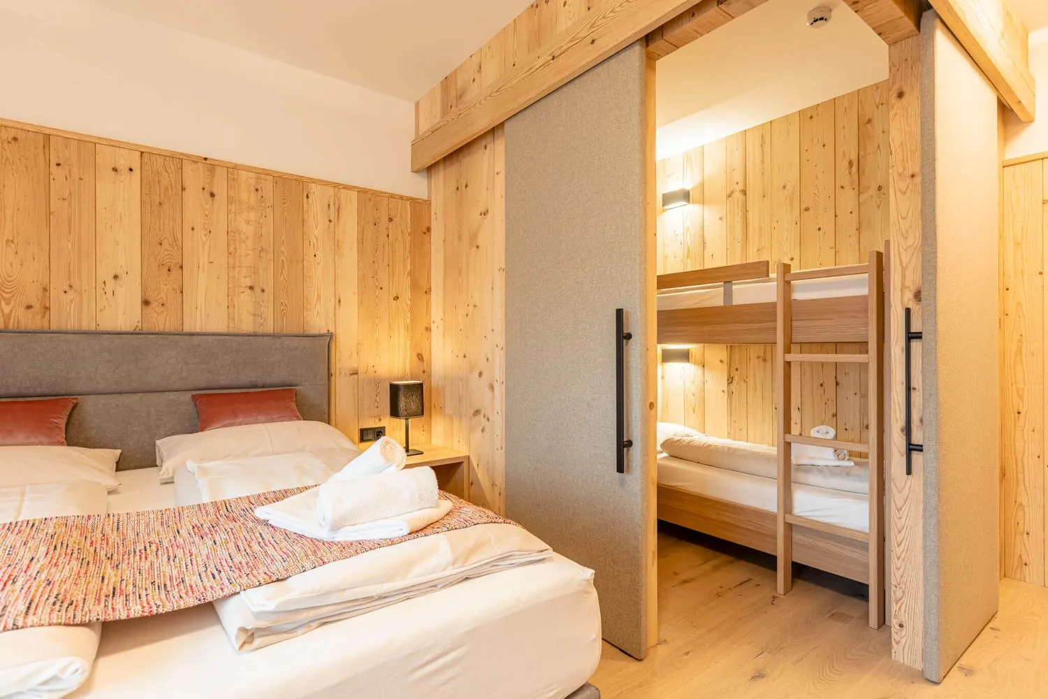 Schlafzimmer mit Doppelbett und Etagenbett in Holz