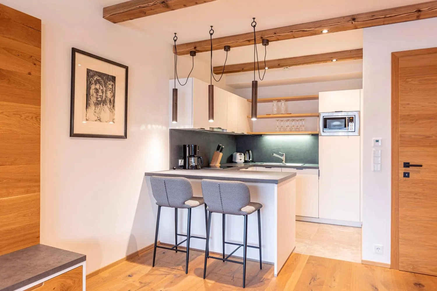Offene Küche mit Theke, Barhockern und Deckenbalken