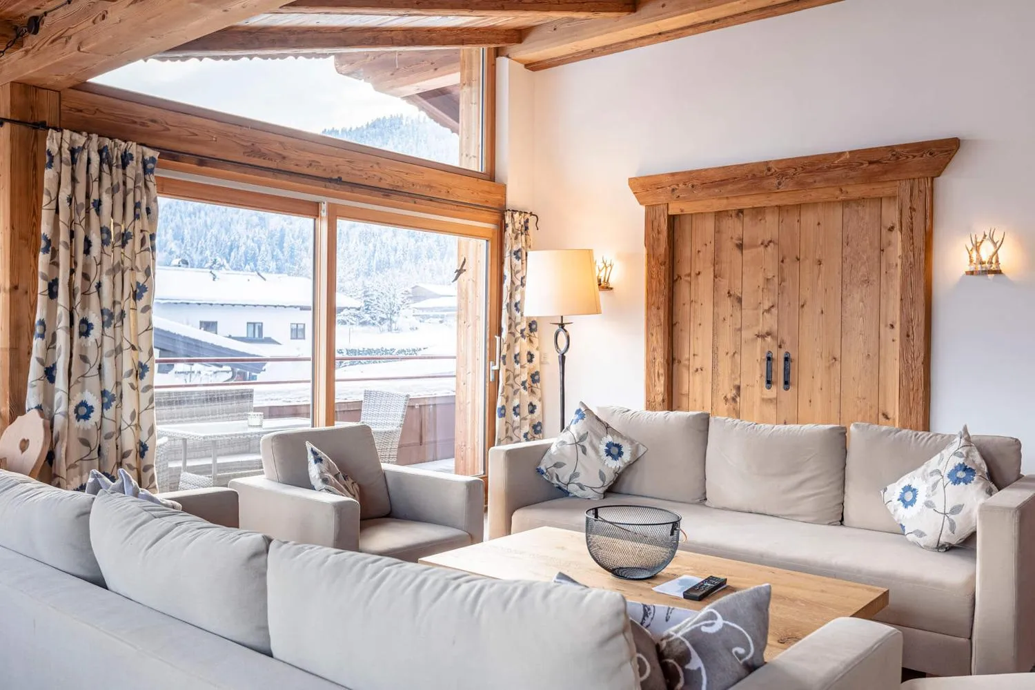 Großes Wohnzimmer mit Sofas und Panorama-Bergfenster