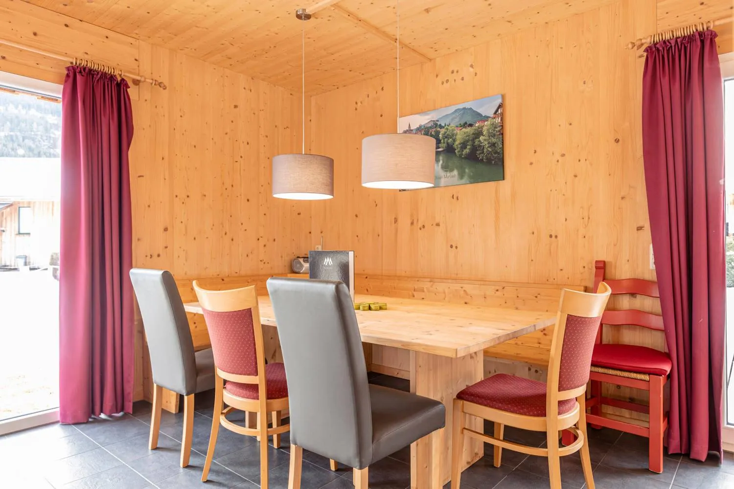 Essbereich mit Holztisch, Stühlen und beigen Vorhängen