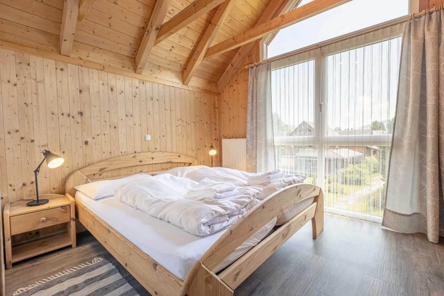 Holz-Schlafzimmer mit Doppelbett und Panoramafenster