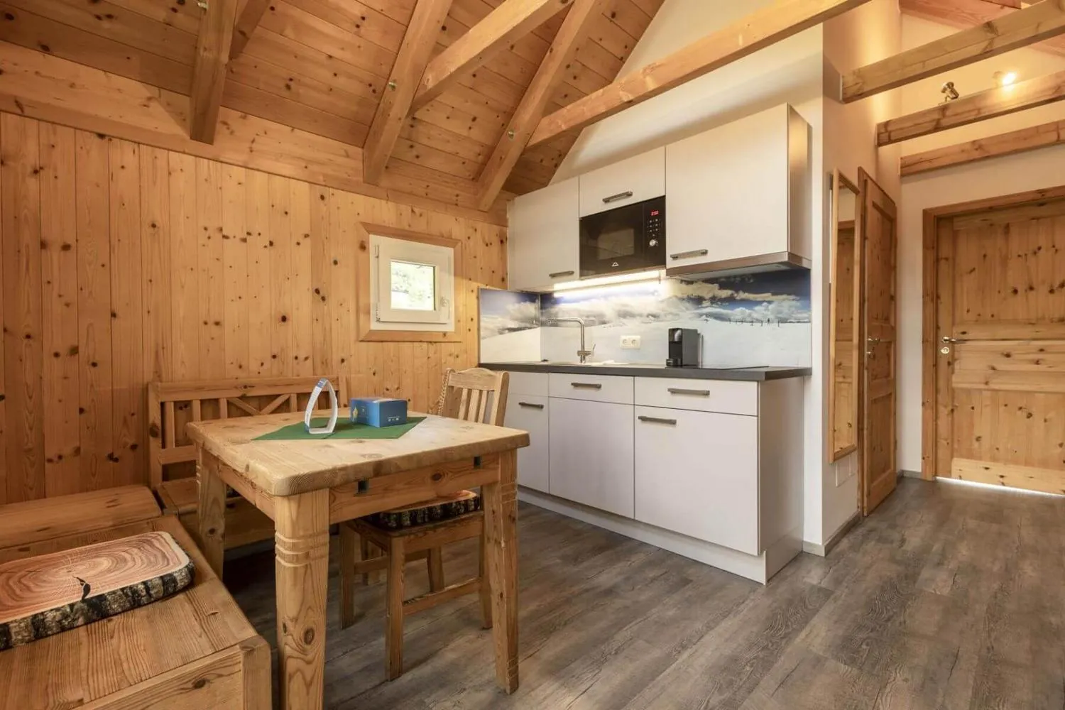 Kleine Kochnische mit Holztisch und Sitzbereich