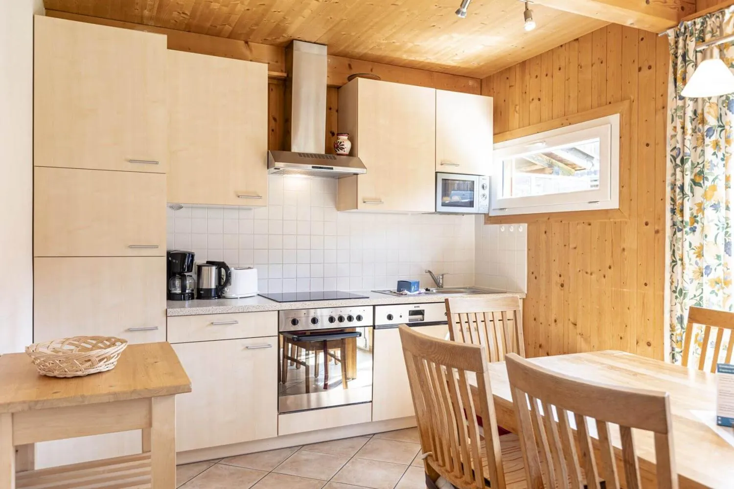 Moderne Küchenzeile mit weißen Fronten und Holzwänden