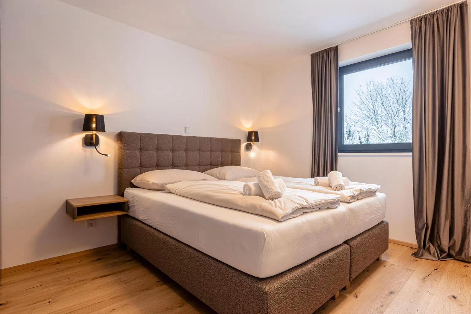 Modernes Schlafzimmer mit eleganter Beleuchtung und Waldblick