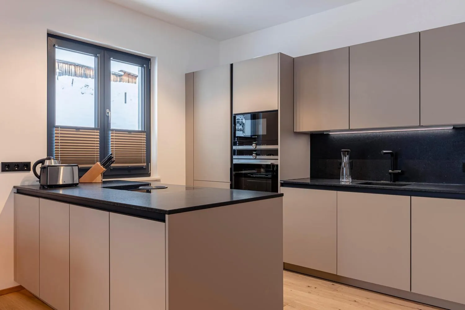 Moderne Küche mit schwarzer Arbeitsplatte und Fensterbank