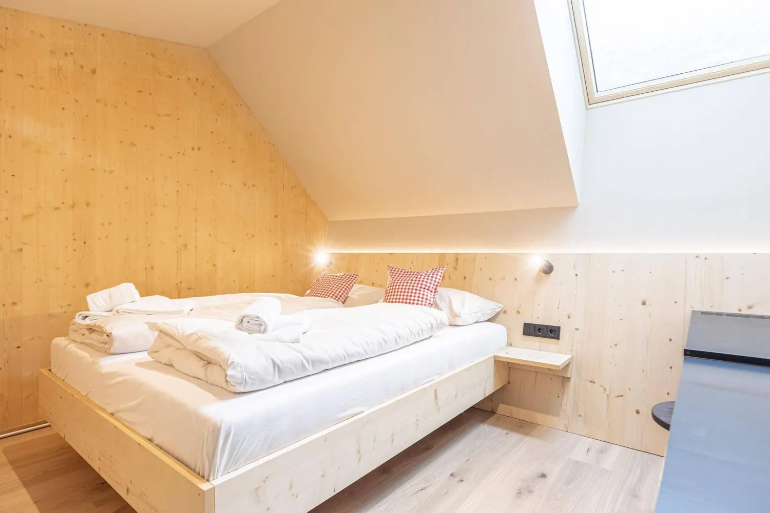 Schlafzimmer unter Dachschräge mit Holzverkleidung und Fenster