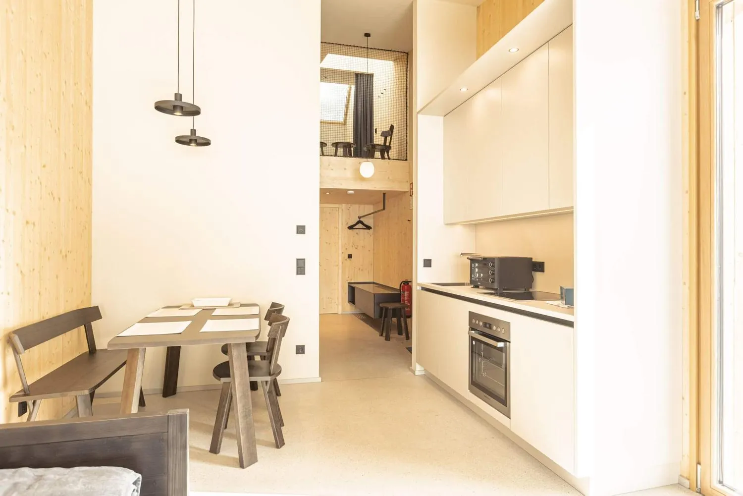 Offene Küchenzeile mit Essplatz in moderner Holzarchitektur