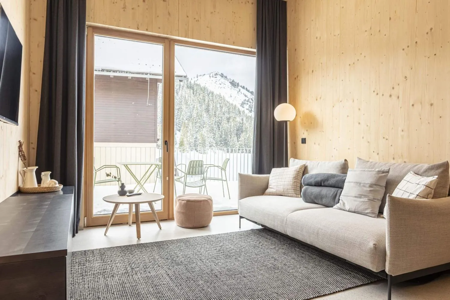 Wohnzimmer mit großem Fenster und Blick aufs Bergpanorama