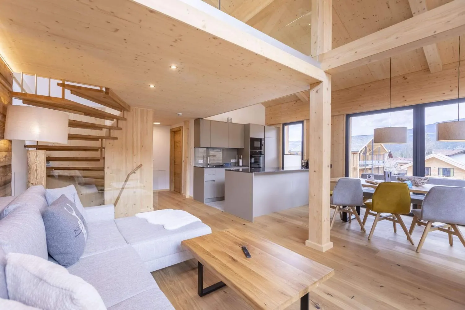 Modernes Loft-Wohnzimmer mit Holztreppe und Bergpanoramablick