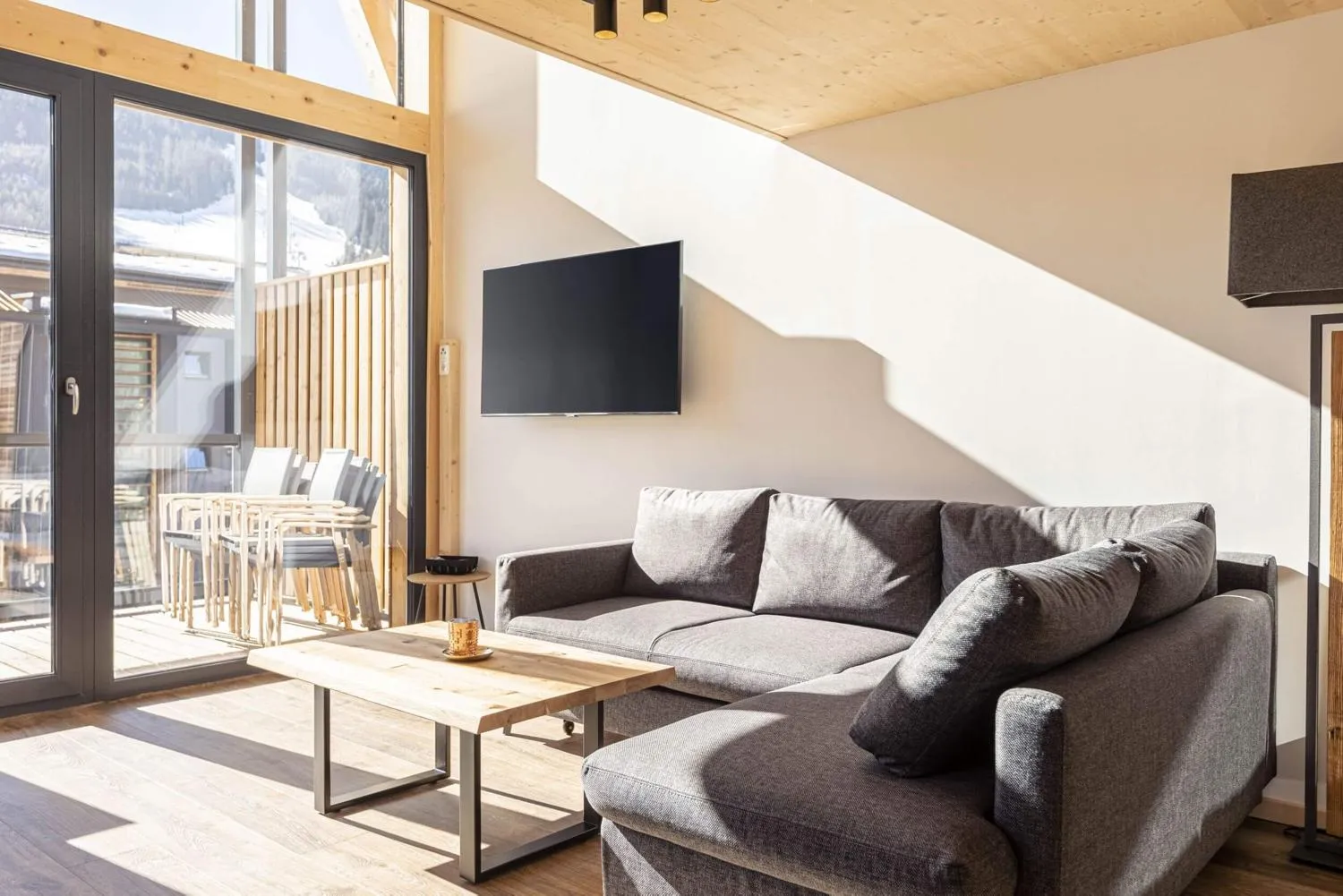 Moderne Küchenzeile in Weiß-Grau mit Holzverkleidung und Terrassenzugang