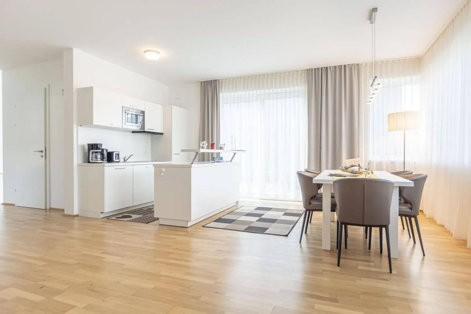 Moderne weiße Küche mit Essbereich und Panoramafenster