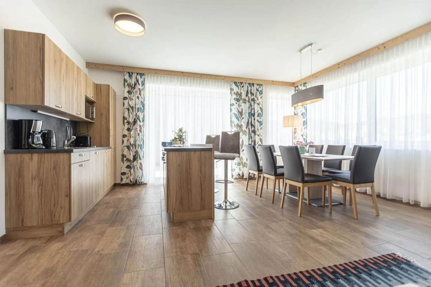 Offene Küche mit Holzfronten, Kochinsel und Pflanzen