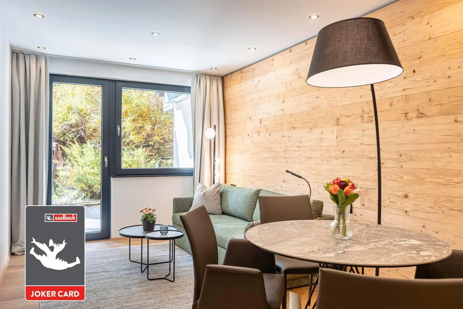 Schlafzimmer mit leuchtender Holzwand und Balkonzugang