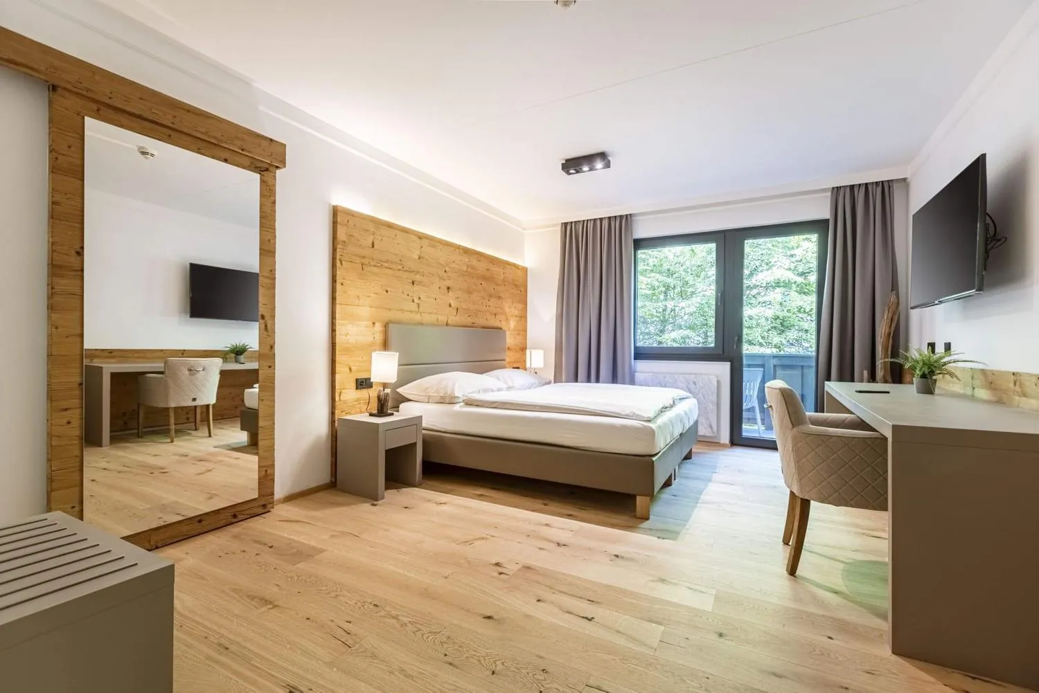 Zweites Schlafzimmer mit Holzrückwand und Terrassenzugang