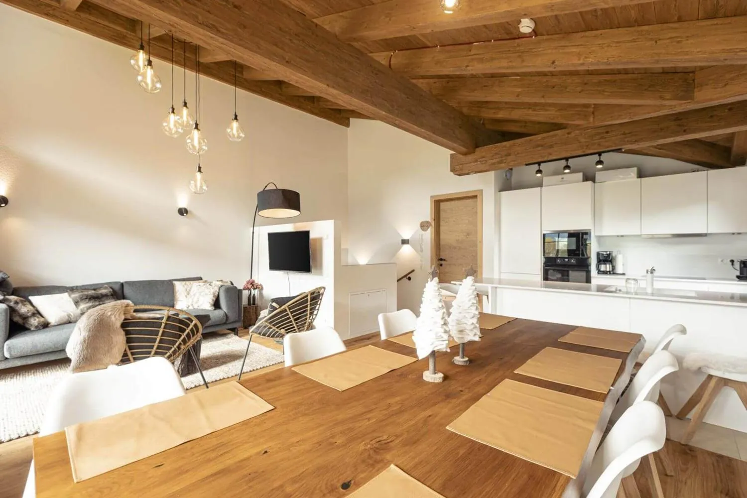 Essbereich mit großem Holztisch, Lederstühlen und Bergfenster, Kaminofen sichtbar