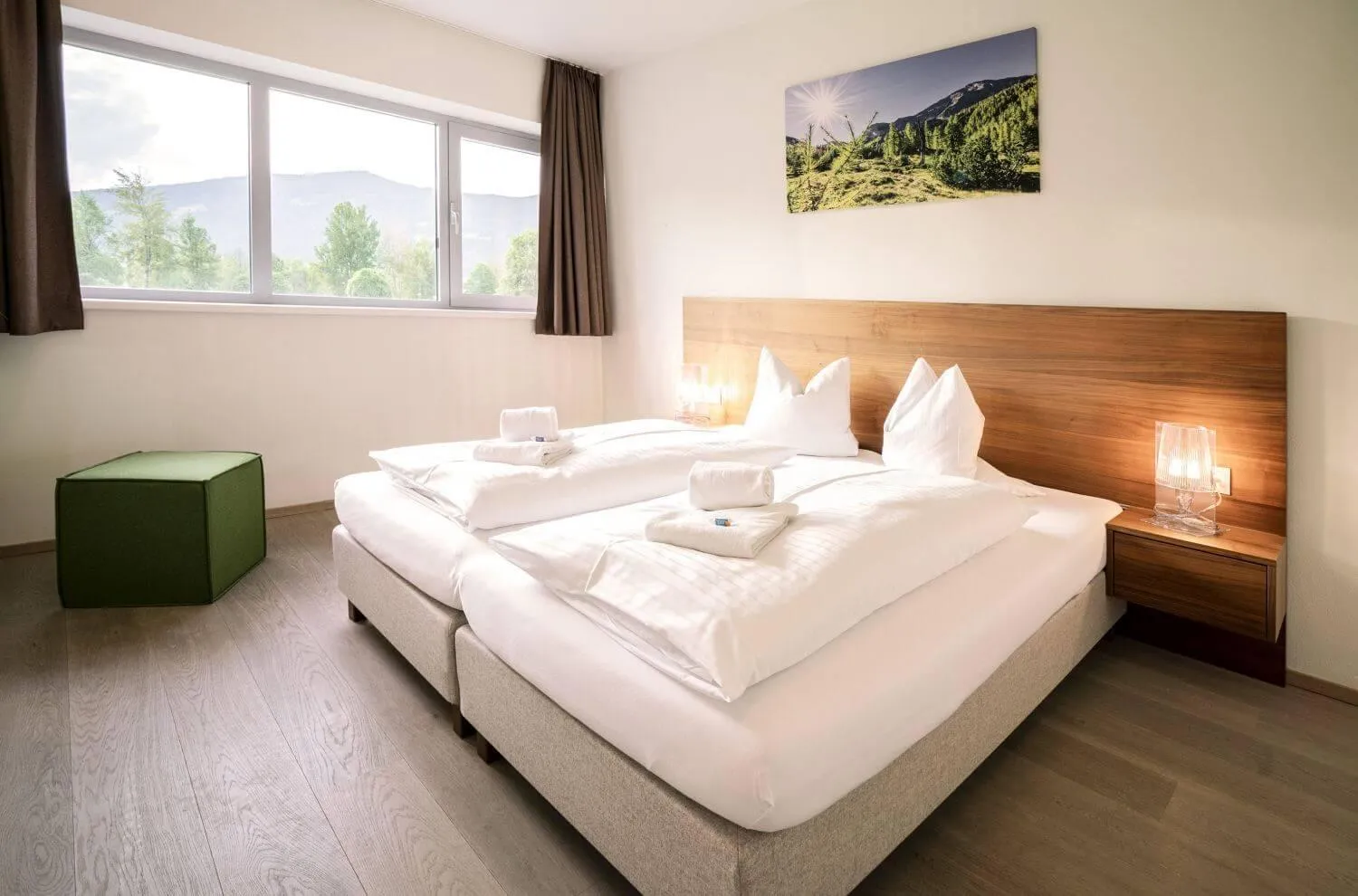 Schlafzimmer mit Doppelbett, Holzdetails, Sommertal und Waldblick